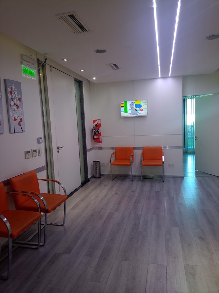 Sala de espera con sillones naranjas y televisor